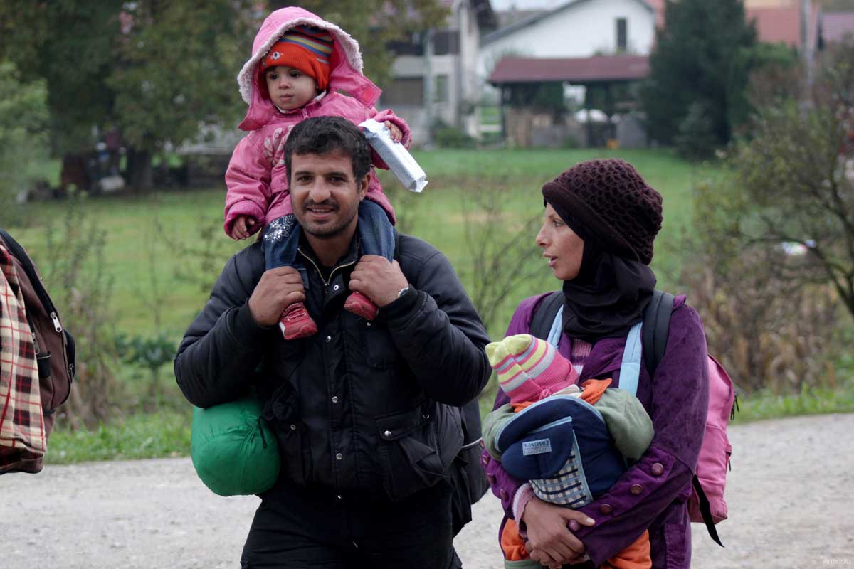 A family is seen walking near the Slovenia-Croatia border