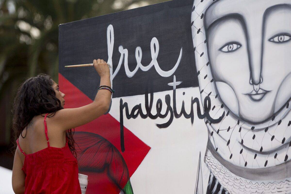 A woman artist paints a mural in support to the Women Peace Flotilla, two sailing boats named Amal-Hope and Zaytouna-Oliva, with only female activists on board, before it sets off for the Gaza Strip from the port of Barcelona under the banner "The Women's Boat to Gaza" to break the Israeli blockade on Gaza on September 14, 2016 in Barcelona, Spain. ( Albert Llop - Anadolu Agency )