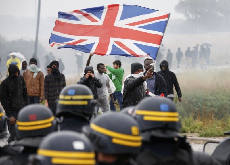 Tear gas fills the air as French police face off with demonstrators in the camp "jungle" where migrants live in Calais, France, October 1, 2016. [Reuters/Pascal Rossignol]