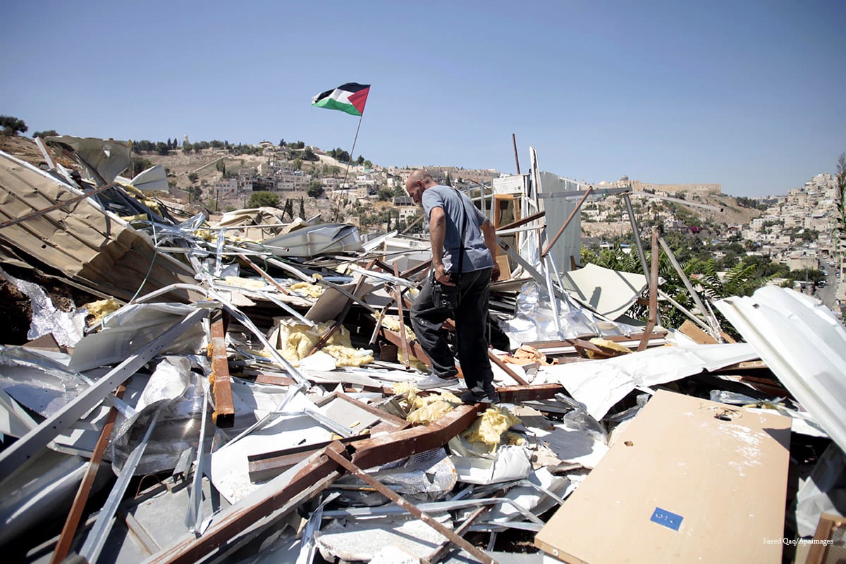 A Palestinian man searches through the rubble of his home in Silwan, East Jerusalem, after Israeli forces demolished it, on 26 August, 2013 [Saeed Qaq/Apaimages]