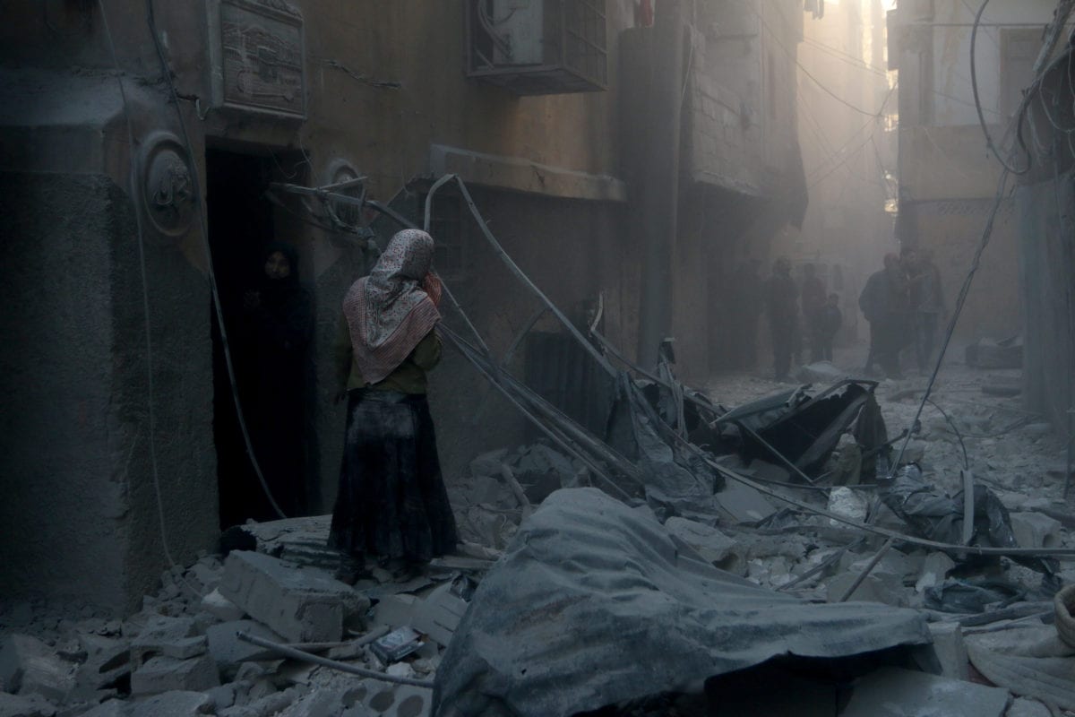 Syrian woman walks among the scene of the air strikes that were carried out by Syria and Russia in Aleppo, Syria on 21 November 2016 [Jawad al Rifai/Anadolu Agency]