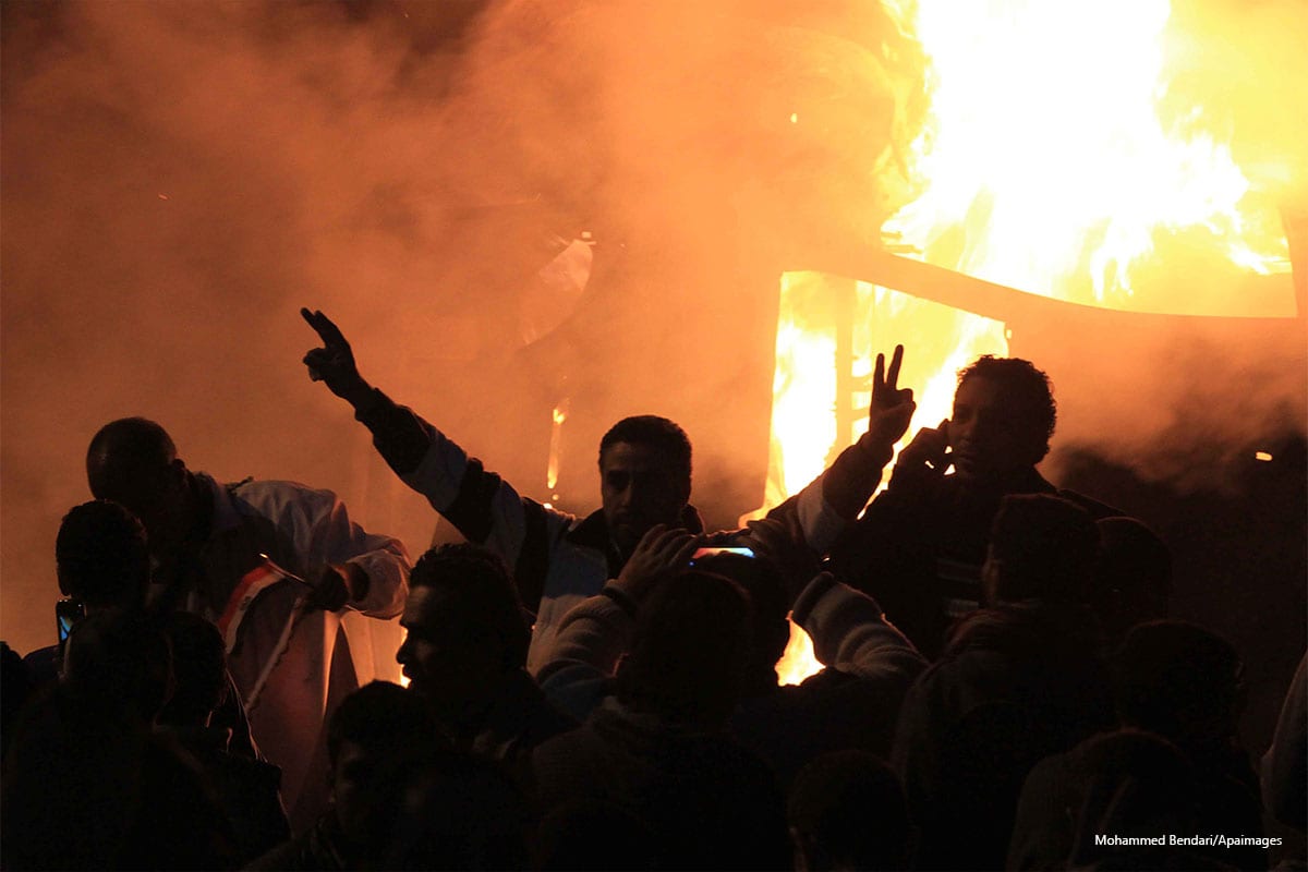 Angry Egyptians set fire to a microbus after passengers allegedly held up four fingers, the symbol known as "Rabaa" in Cairo on December 24 2013 [Mohammed Bendari/Apaimages]