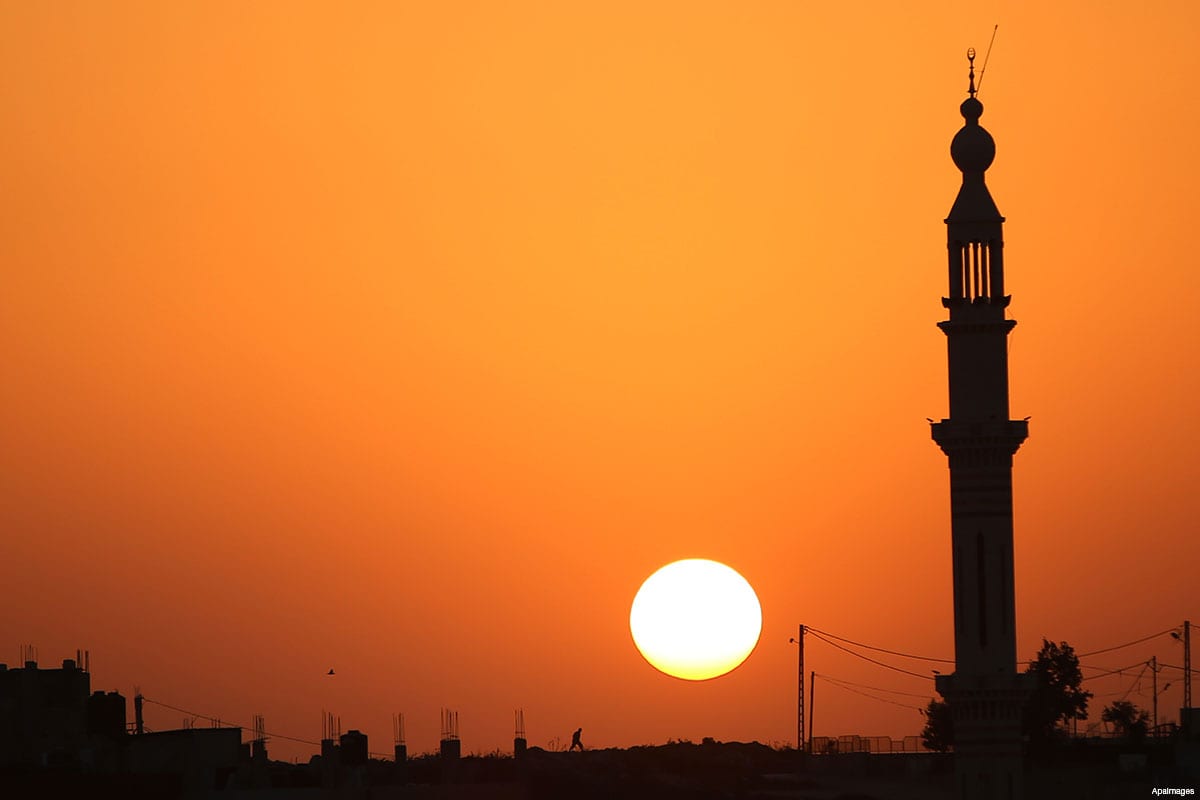The sun sets behind the minaret of Hera' mosque, in Jalazoun refugee camp, near the West Bank city of Ramallah, on August 9, 2015 [Shadi Hatem / ApaImages]