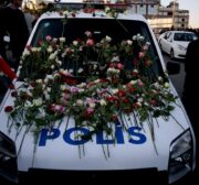 A police vehicle with flowers is seen as people gather for the victims of Istanbul terror attacks near the Vodafone Arena in Istanbul's Besiktas, Turkey on December 11, 2016 [Onur Çoban / Anadolu Agency]