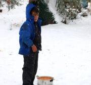 A Syrian boy receives food aid at a tent city as it snows in the Azaz town of Aleppo, Syria on 21 December 2016. [Mamun Ebu Omer - Anadolu Agency]