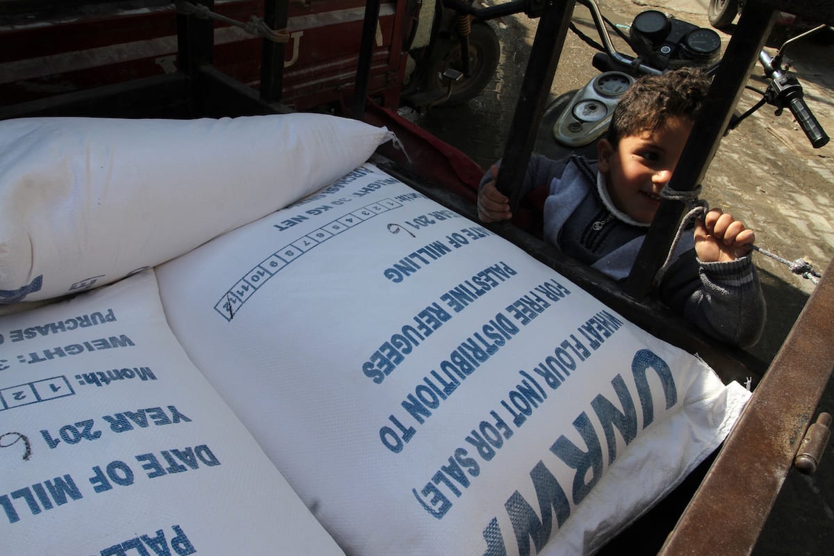 A Palestinian child stands next to the food aid given by UNRWA in Rafah, Gaza on 22 January 2017 [Abed Rahim Khatib/Anadolu Agency]