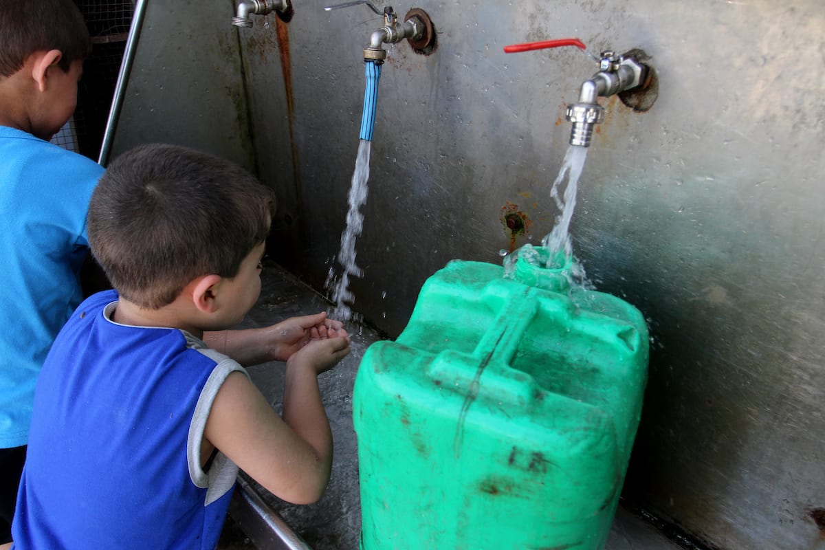 Palestinian boys drink a water from a public tap in Rafah in the southern Gaza strip, on May 22, 2016 [Abed Rahim Khatib/Apa Images]