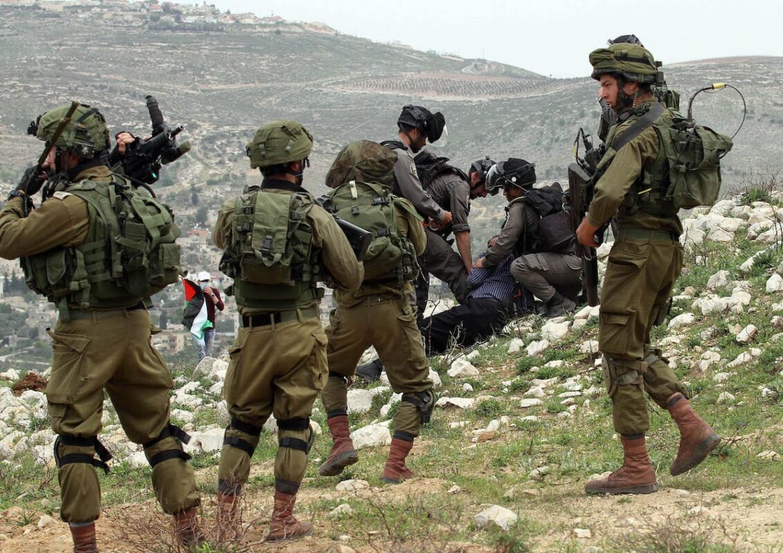 Israeli soldiers can be seen harassing Palestinians in the West Bank on 30 March 2017 [Nedal Eshtayah/Anadolu Agency]