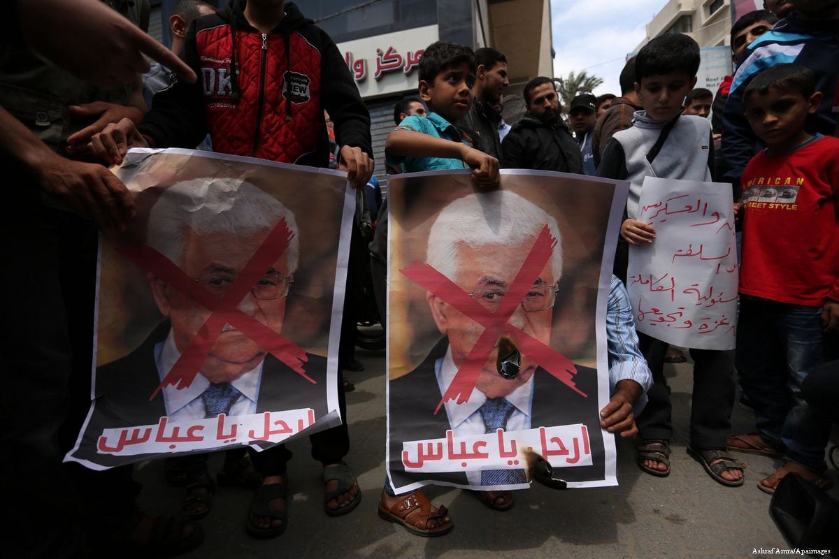 Hamas supporters carry posters depicting Palestinian President Mahmoud Abbas with a red cross during a protest in Khan Younis, Gaza Strip on 14 April 2017 [Ashraf Amra/Apaimages]
