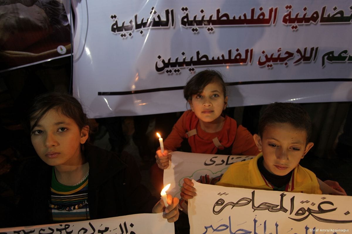 Image of Palestinian children holding banners in solidarity with Palestinian refugees in Syria [Ashraf Amra/Apaimages]