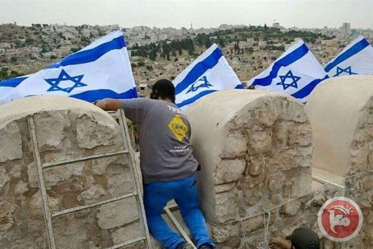 Settlers fly Israeli flag over Hebron's Ibrahimi Mosque on 2 April 2017 [Ma'an News]