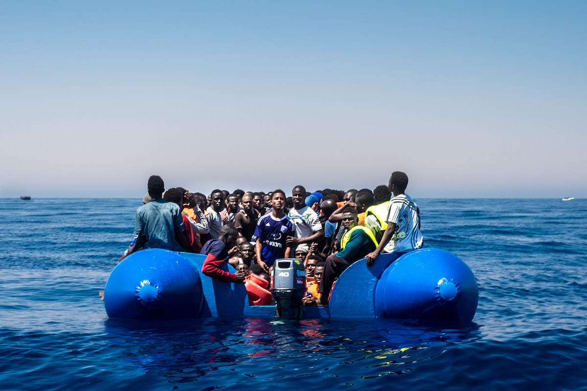 Refugees wait to get on onboard the rescue vessel after being rescued in the Mediterranean Sea near Libya. [Marcus Drinkwater / Anadolu Agency]