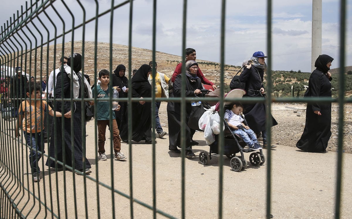 Syrians pass through Cilvegozu border gate to reach their hometown before Eid Al-Fitr in Reyhanli, Hatay on 21 June 2017 [Cem Genco/Anadolu Agency]