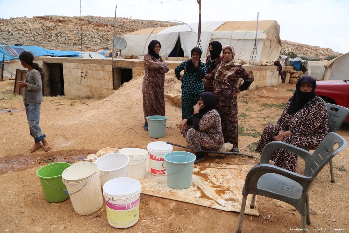 Syrian women living in a refugee camp, fill their buckets with water in Idlib, Syria on 23 June 2017 [İsmihan Özgüven/Anadolu Agency]