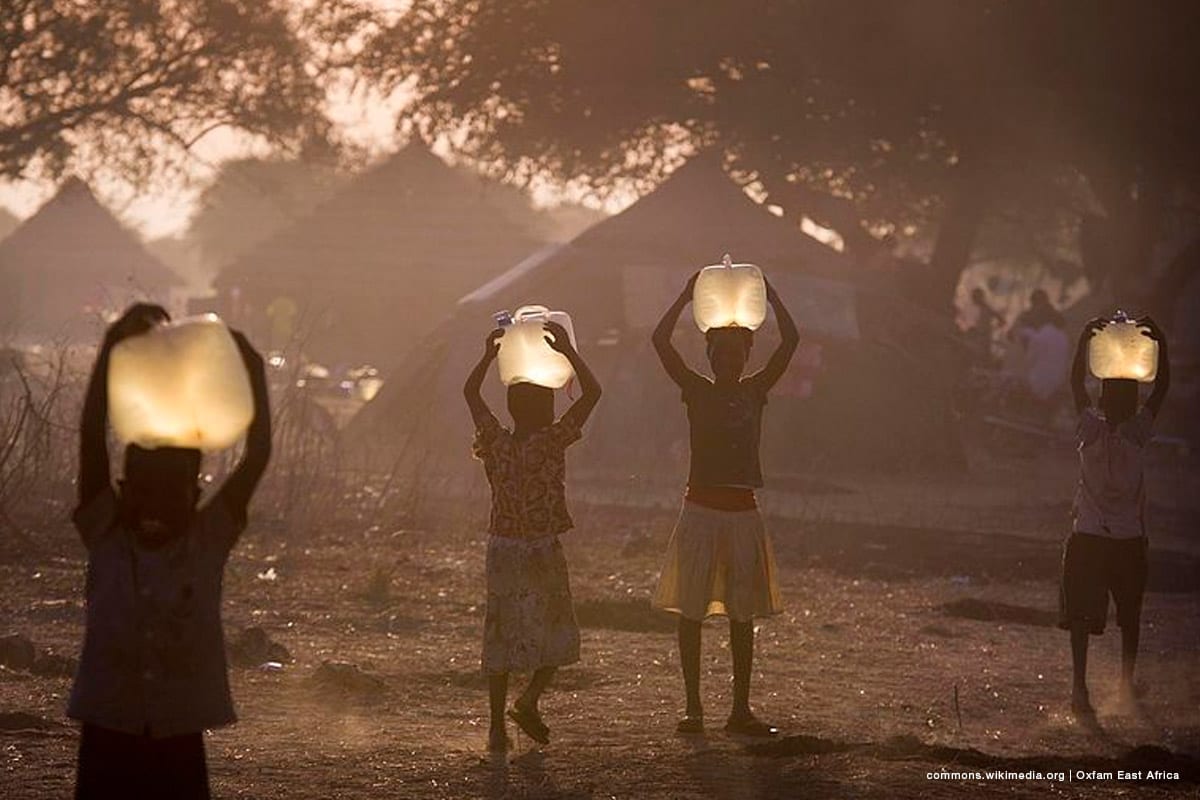 Children collect water for their families at sunset. Oxfam is currently producing over 300,000 litres of clean water a day for a population of around 80,000 displaced people who have settled in Awerial county, South Sudan. Clean water for drinking and cooking significantly reduces the risk of deadly water-borne diseases like cholera. [Image: commons.wikimedia.org | Oxfam East Africa ]