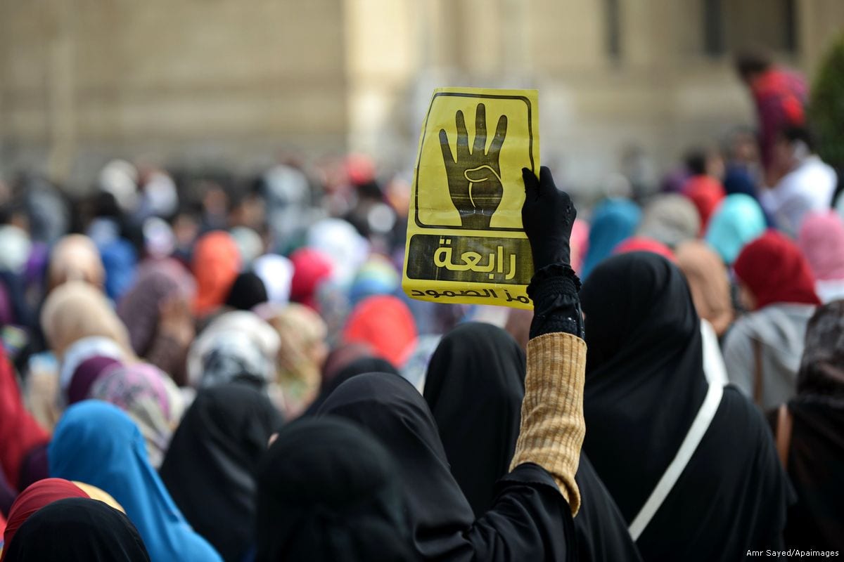 An Egyptian student holds the Rabaa sign during a protest against the military rule on 18 February 2015 [Amr Sayed/Apaimgaes]
