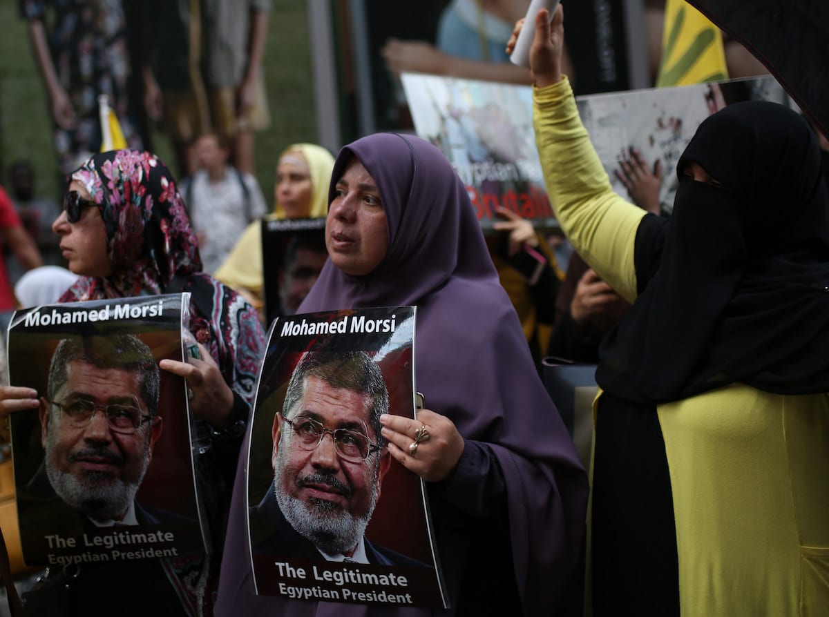 A woman holds a poster reading 'Mohamed Morsi, The Legitimate Egyptian President' during a protest marking the 4th anniversary of the Rabaa massacre in New York, US on 13 August 2017 [Mohammed Elshamy/Anadolu Agency]