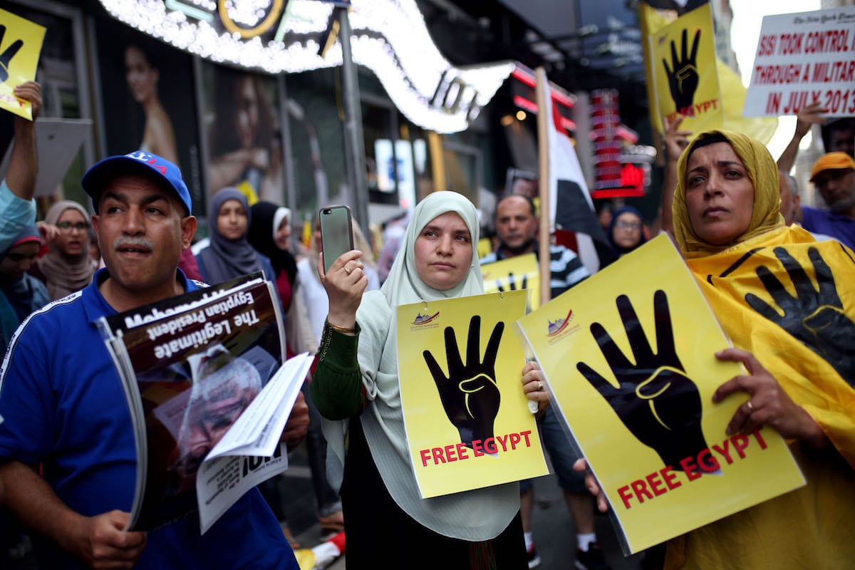 Women hold banners reading 'Free Egypt' during a protest marking the fourth anniversary of Rabaa Al-Adawoya massacre in Times Square, New York, United States on 13 August 2017 [Mohammed Elshamy/Anadolu Agency]
