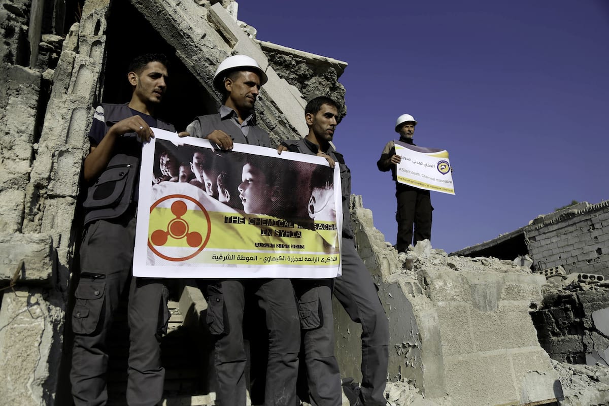 Men, members of Syrian civil defense organization, White Helmets let a white pigeon to fly for people who lost his life in chemical attack that in the Eastern Ghouta region of Damascus, Syria on 22 August, 2017 [Amer Almohibany/Anadolu Agency]