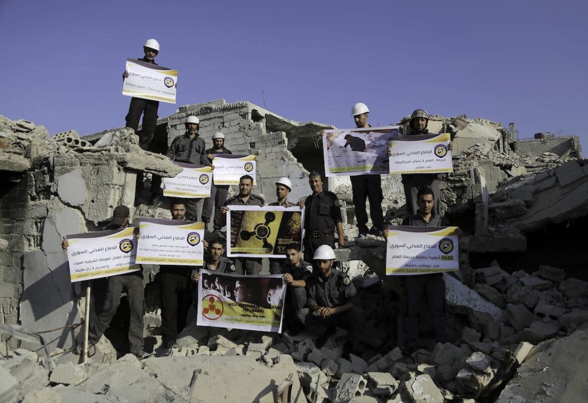 Men, members of Syrian civil defense organisation, White Helmets release a white pigeon for people who lost their life in a chemical attack in Damascus, Syria on 22 August, 2017 [Amer Almohibany/Anadolu Agency]