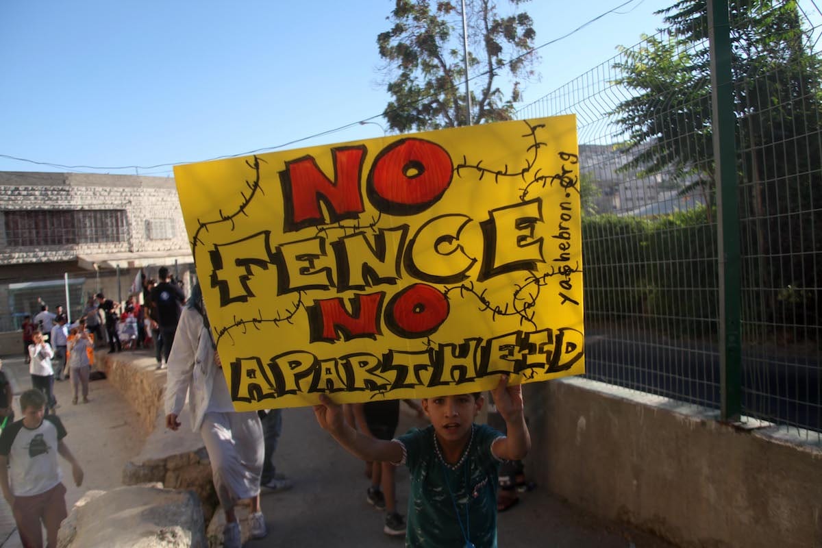 Palestinians hold banners reading 'Segregated and Unequeal' during a protest against Israeli restrictions in Hebron, West Bank on 28 August 2017 [Mamoun Wazwaz/Anadolu Agency]