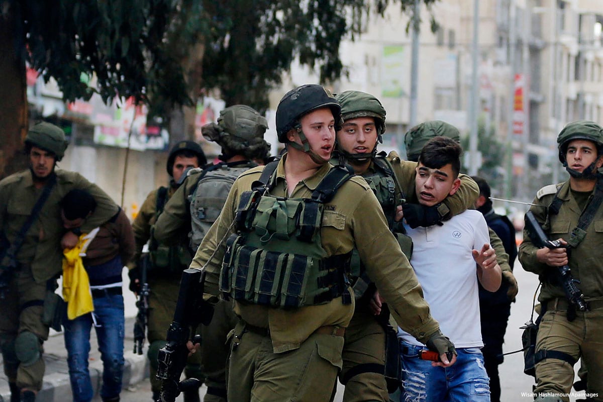 Israeli security forces take a Palestinian minor into custody in the West Bank on 20 December 2017 [Wisam Hashlamoun/Apaimages]