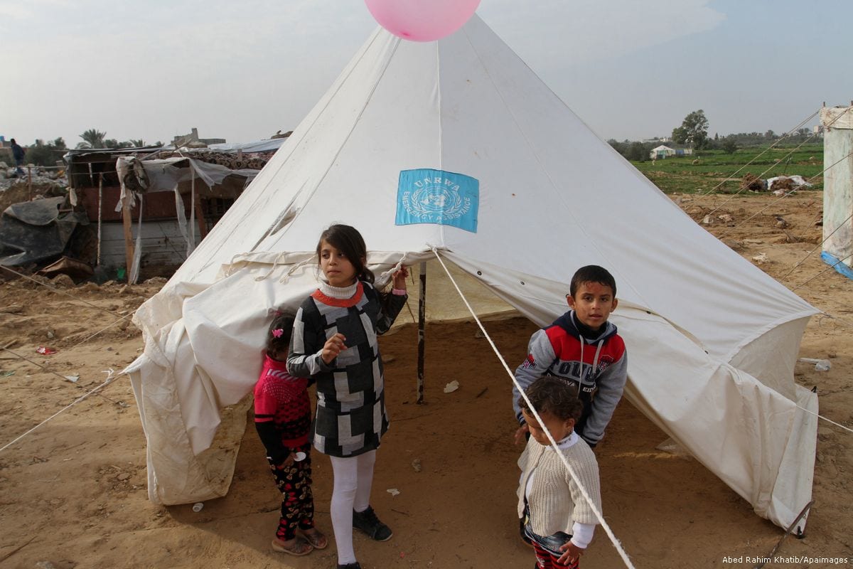 Palestinian children play outside tents set up by UNRWA in Gaza [Abed Rahim Khatib/Apaimages]