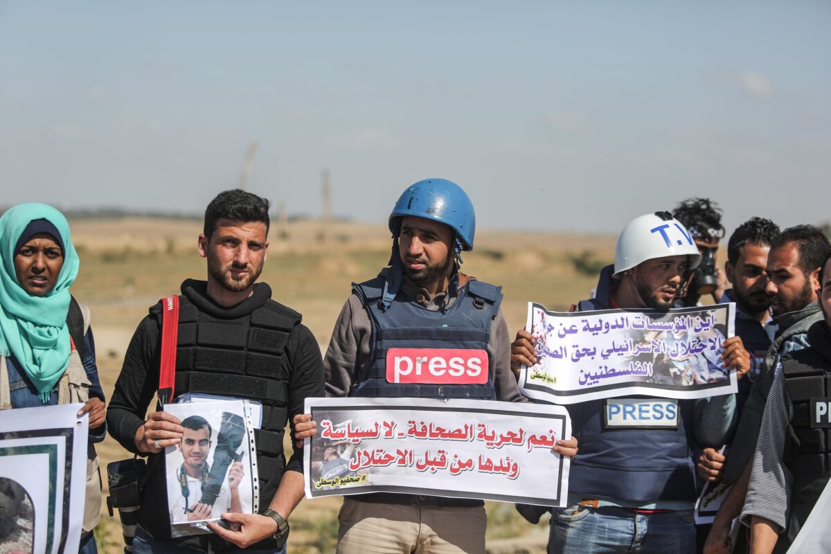 Palestinian journalists hold placards to commemorate their Palestinian colleague Yasir Murteca, who was martyred by Israeli soldiers during "Great March of Return" near Gaza-Israel border, during a protest in Gaza City, Gaza on 9 April, 2018 [Ali Jadallah/Anadolu Agency]