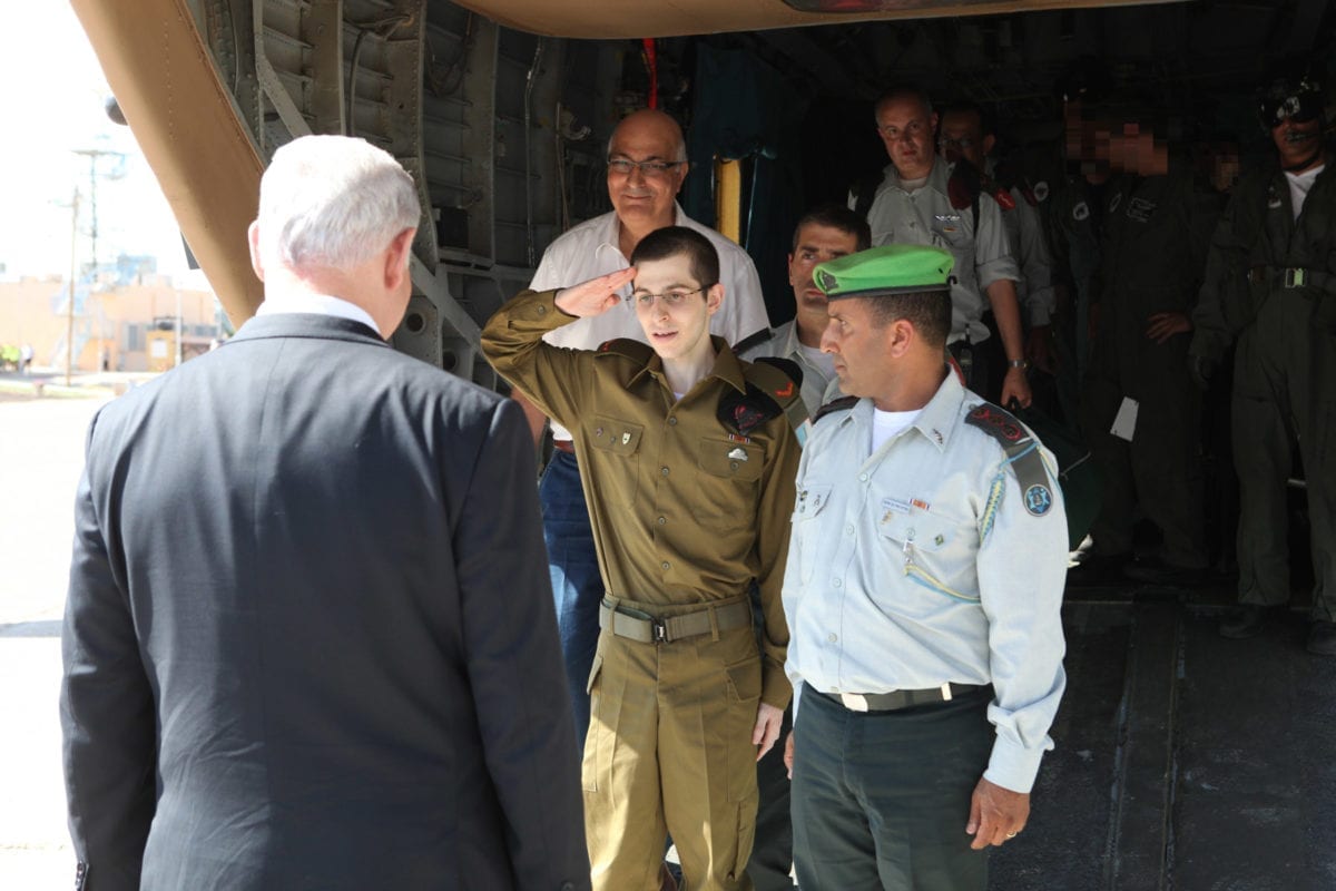 Freed Israeli soldier Gilad Shalit salutes Israel Prime Minister Benjamin Netanyahu after landing in an Israeli army air base. Shalit was released on October 18 2011 after being held as a prisoner of war for five and a half years in the occupied Gaza Strip [IDF Online]