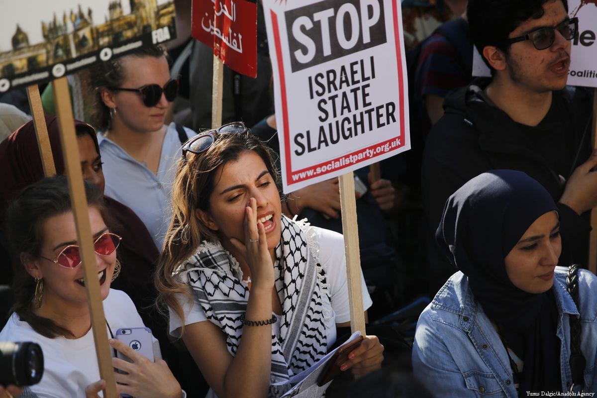 Pro-Palestine demonstrators hold placards and wave flags during a protest opposite the entrance to Downing Street in London, UK on 15 May 2018 [Yunus Dalgic/Anadolu Agency]