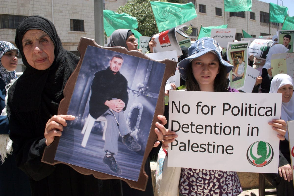 Palestinians hold up pictures of relatives who were arrested and imprisoned for political reasons by Palestinian Authority security forces, during a protest in the West Bank city of Hebron, on June 09,2011 [Najeh Hashlamoun / ApaImages]