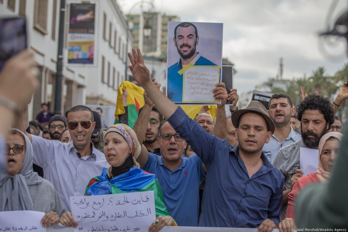 A group of people hold banners during a demonstration against the prison sentence for Rif Movement leader Nasser Zefzafi and members along with him, in front of the parliament building in Rabat, Morocco on 27 June 2018 [Jalal Morchidi/Anadolu Agency]