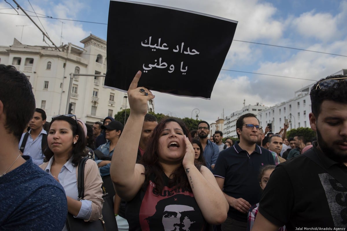 A group of people hold banners during a demonstration against the prison sentence for Rif Movement leader Nasser Zefzafi and members along with him, in front of the parliament building in Rabat, Morocco on 27 June 2018 [Jalal Morchidi/Anadolu Agency]