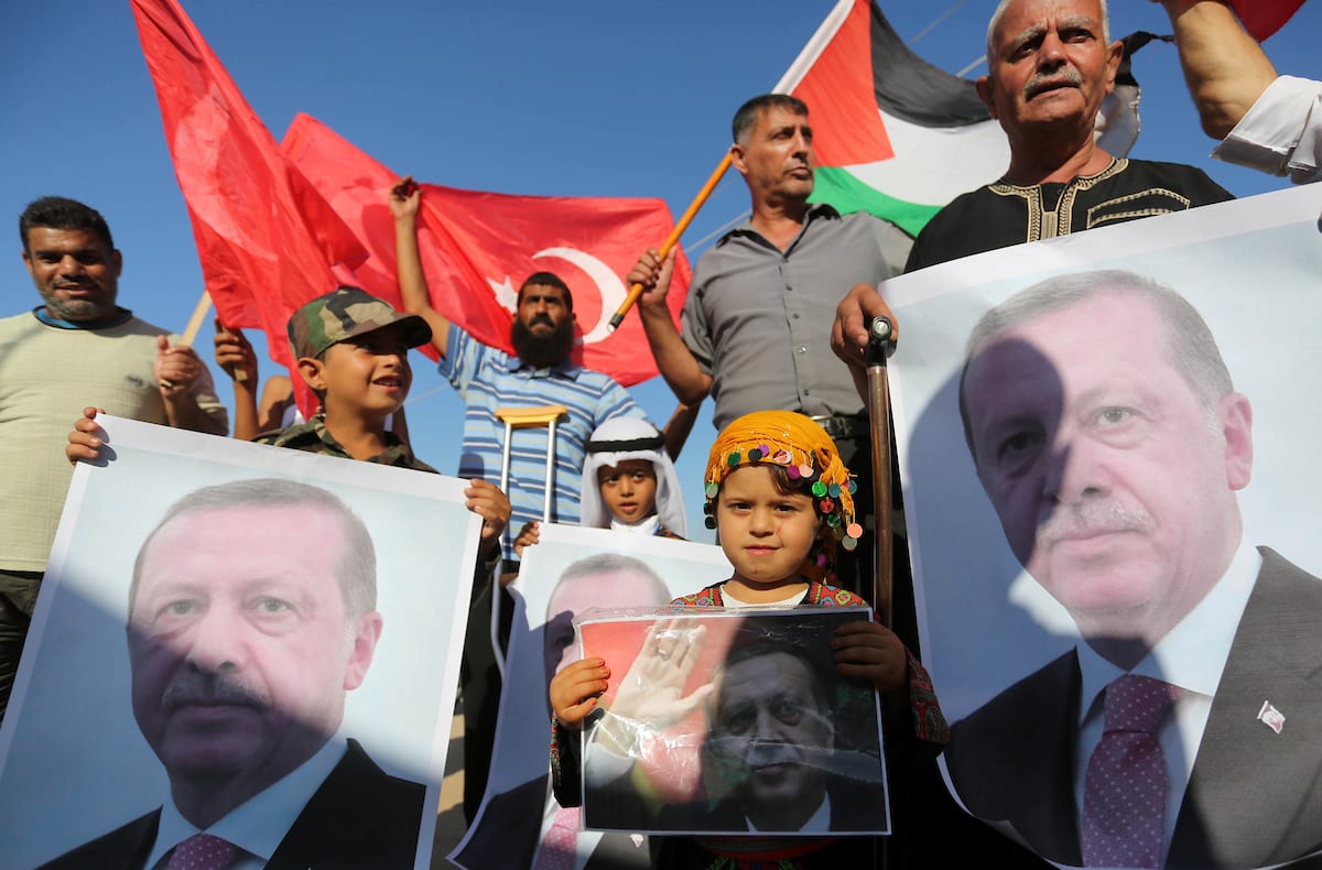 Palestinians hold portraits of Turkish President Recep Tayyip Erdogan during a rally to support with Turkey's presidential and parliamentary elections in Al-Bureij in the center of Gaza Strip on 24 June, 2018 [Ashraf Amra/Apaimages]