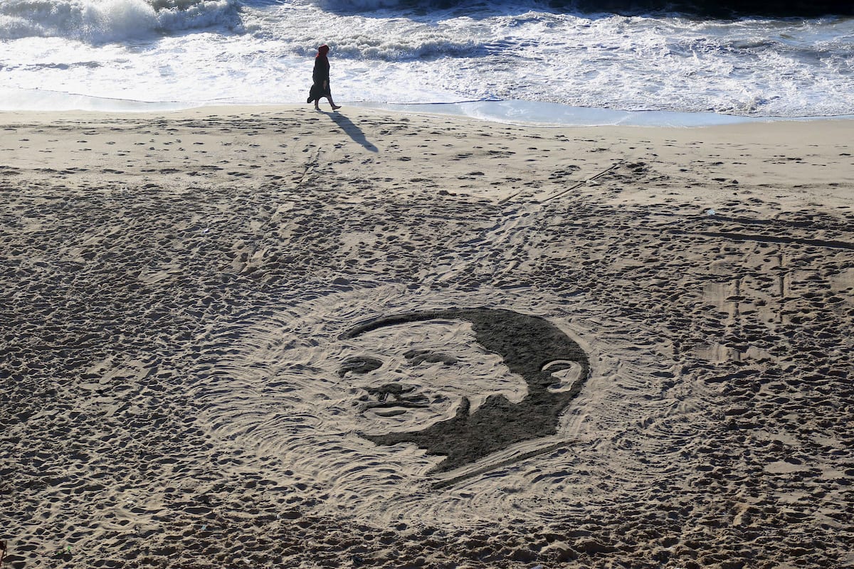 A Palestinian artist Osama Sbeata draws the portrait of Turkish President Recep Tayyip Erdogan on sand to celebrate the results of the Turkish presidential and parliamentary elections on Gaza Sea on 26 June, 2018 [Abed Abu Ryash/Apaimages]