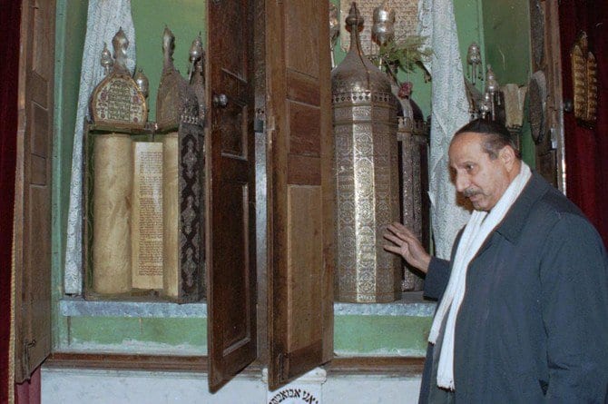 Youssef Jajati, a Jewish community leader in Syria, points out the Torah holy book preserved in a silver container in Joubar’s Synagogue which dates back to 718 BC