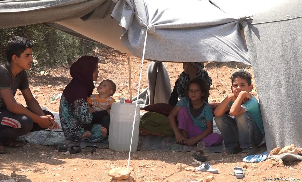 Syrian children wait at the border near Jordan after they fled from the ongoing Syrian regime strikes on Daraa, on 6 July 2018. [Ammar Al Ali/Anadolu Agency]