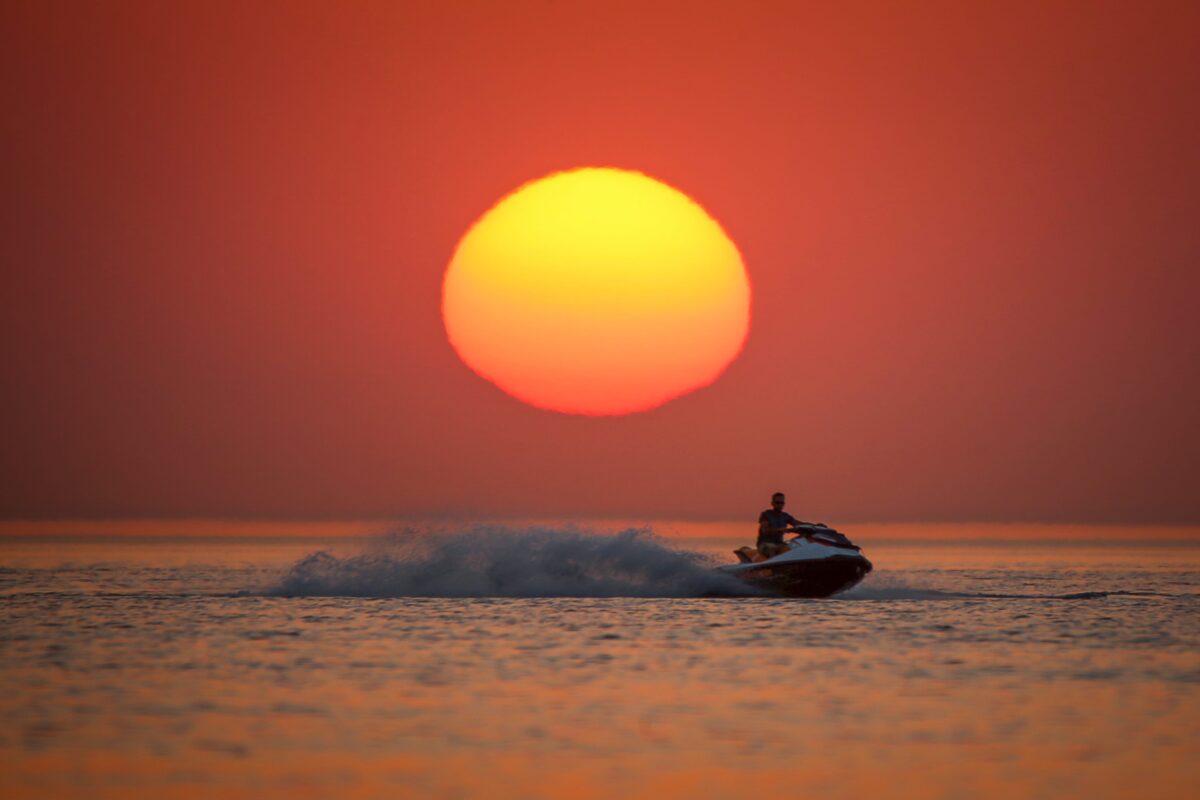 A man rides a jet ski through coastal side during a sunset at the second public beach of Lake Van, in Van, Turkey on 12 July, 2018 [Özkan Bilgin/Anadolu Agency]