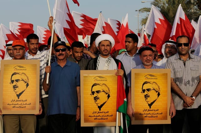 Bahraini anti-government protesters, led by Sheikh Ali Salman, head of the largest Shia opposition group Al-Wefaq, at center holding a Palestinian flag and a poster, as well as Radhi al-Mousawi, front left, acting leader of the Wa'ad secular liberal opposition group, carry posters and wave national flags during a march in the northern village of Abu Saiba, Bahrain, Friday, Aug. 8, 2014 [Hasan Jamali/Apaimages]