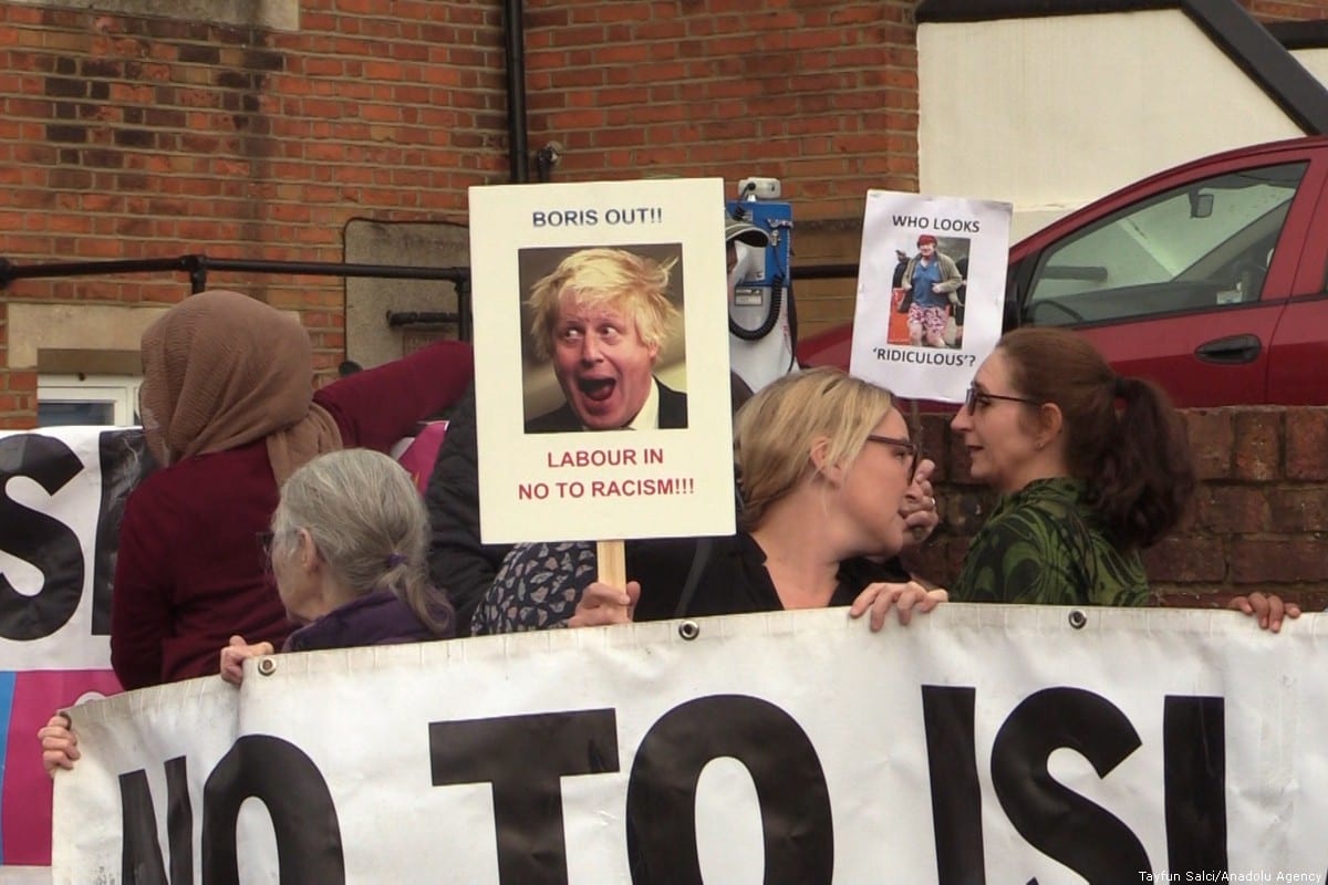 People hold banners during a protest, organized by Stand Up To Racism platform, against former British Foreign Secretary Boris Johnson after his Islamaphobic article, which includes hate crime on women those who wear niqab or burqa, in front of the contact office of Conservative Party in London, United Kingdom on 9 August 2018. [Tayfun Salcı - Anadolu Agency]