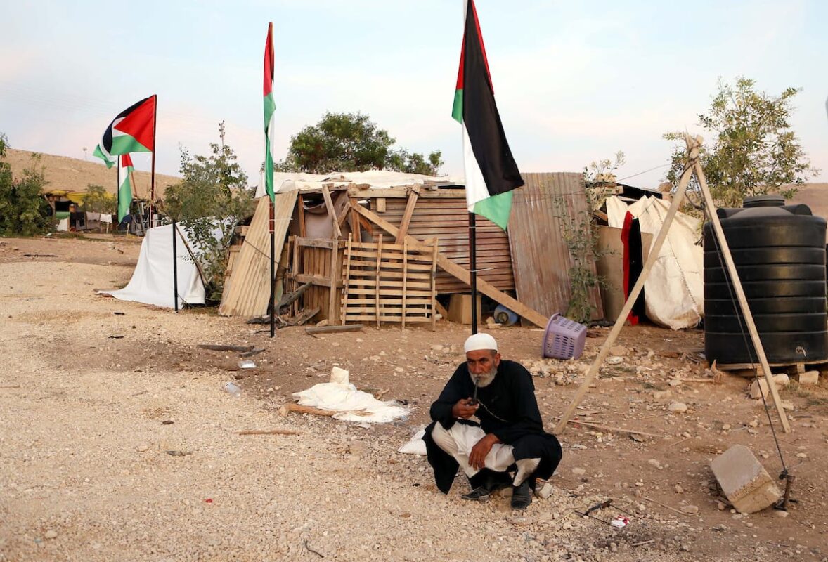A Palestinian man smokes in the village of Khan al-Ahmar in the Israeli occupied West Bank, on 5 October, 2018 [Wisam Hashlamoun/Apaimages]