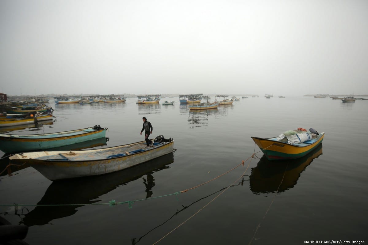 A Palestinian fisherman stands on his boat in Gaza City on 26 February 2017 [MAHMUD HAMS/AFP/Getty Images]