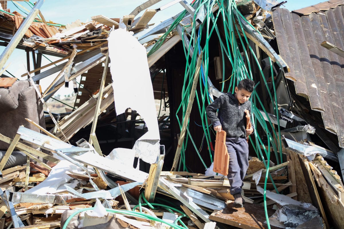 Palestinian Maghribi family collect their belongings amid ruins of their house after Israeli authorities demolished the top part of it in Jabal Al-Mukaber of East Jerusalem on 28 November, 2018 [Mostafa Alkharouf/Anadolu Agency]