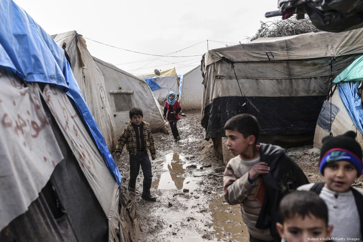 Syrian children walk in the mud after a heavy rain fell at a refugee camp in Syria on 6 February 2016 [Bulent Kilic/AFP/Getty Images]