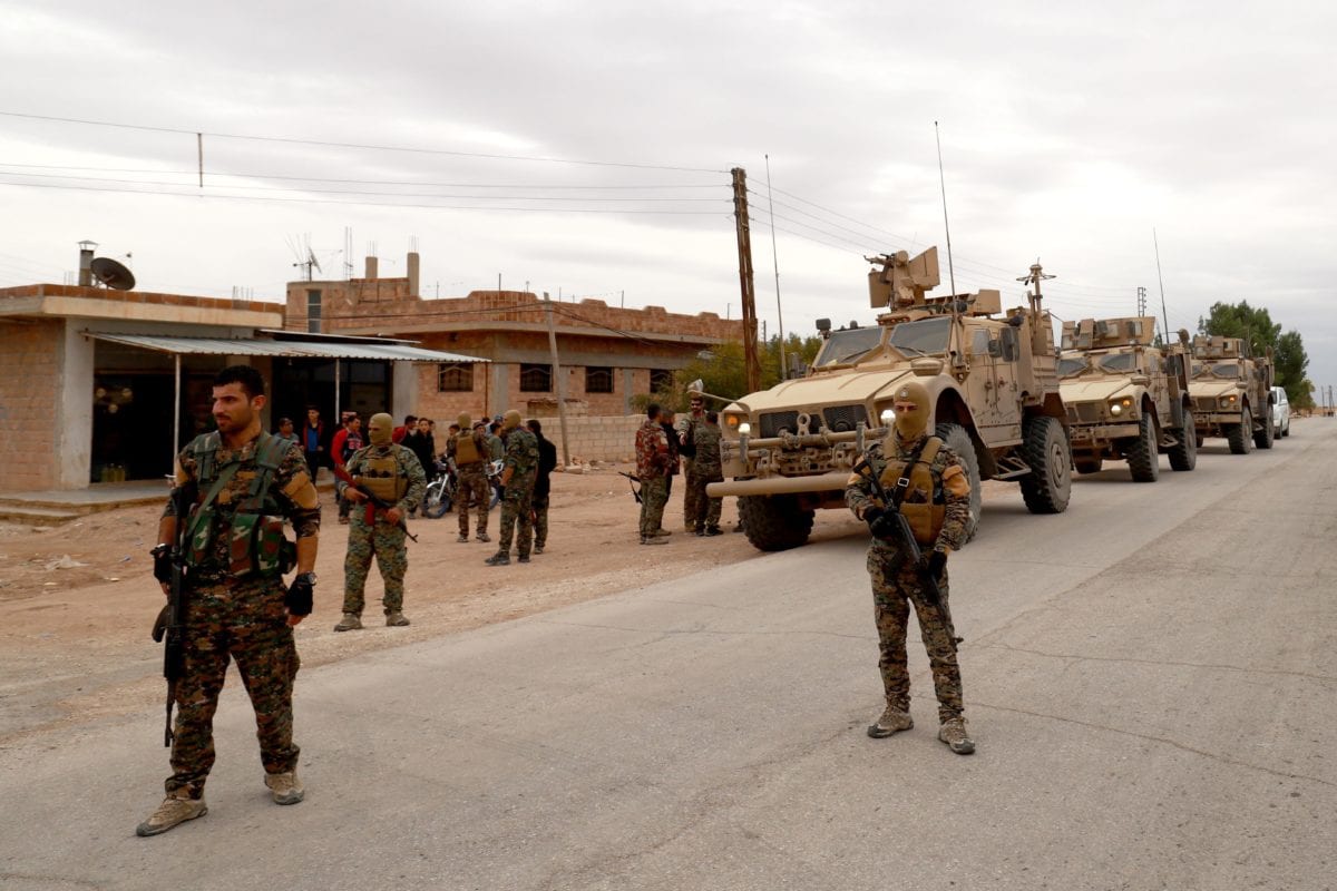 US forces and members of the Syrian Democratic Forces (SDF) patrol the Kurdish-held town of Al-Darbasiyah in northeastern Syria bordering Turkey on November 4, 2018 [DELIL SOULEIMAN/AFP/Getty Images]