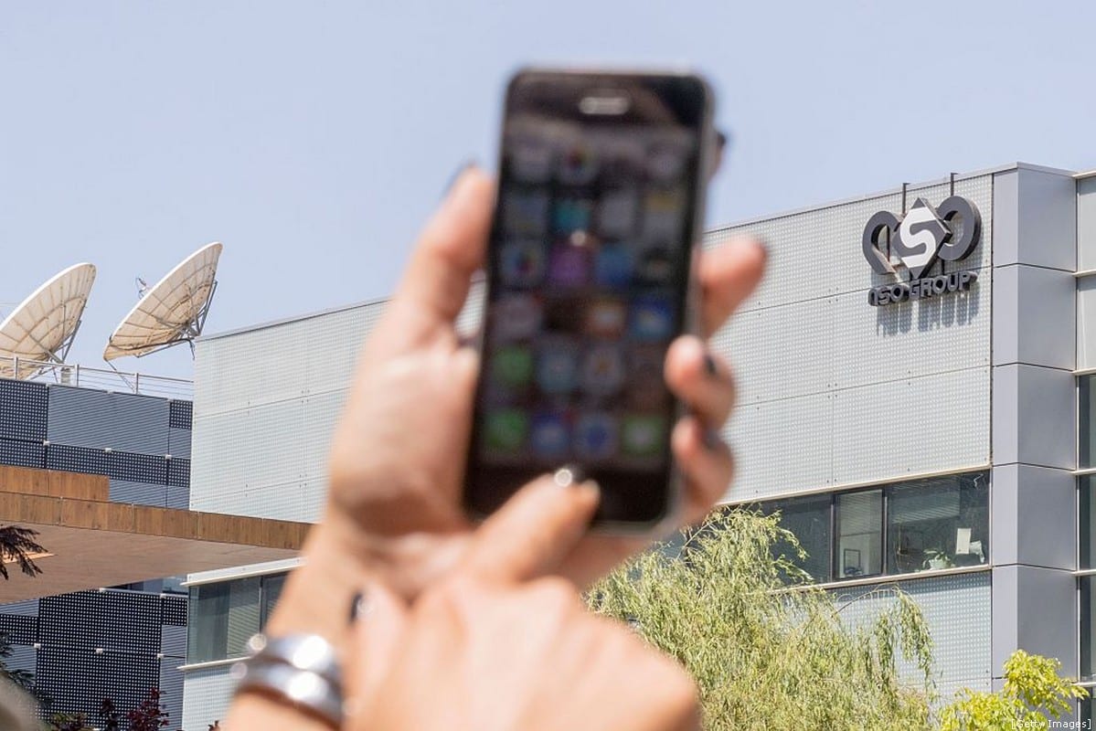 An Israeli woman uses her iPhone in front of the building housing the Israeli NSO group, on 28 August 2016, in Herzliya, near Tel Aviv. [JACK GUEZ/AFP/Getty Images]