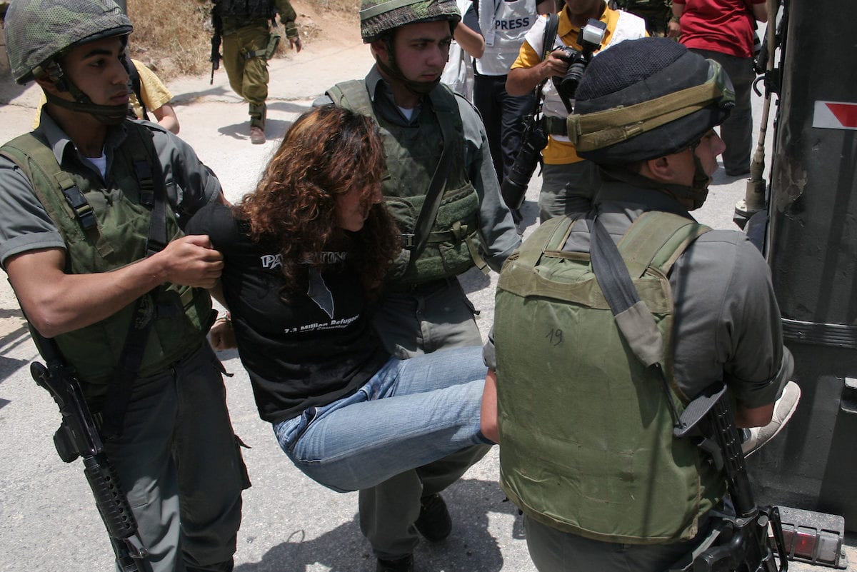 Israeli soldiers arrest a woman protester during a demonstration by Palestinian, Israeli and foreign activists against Israel's controversial separation barrier which crosses the Palestinian territories in the West Bank town of Beit Jala, near the biblical town of Bethlehem, on 27 June 2010 [Mamoun Wazwaz/Apaimages]