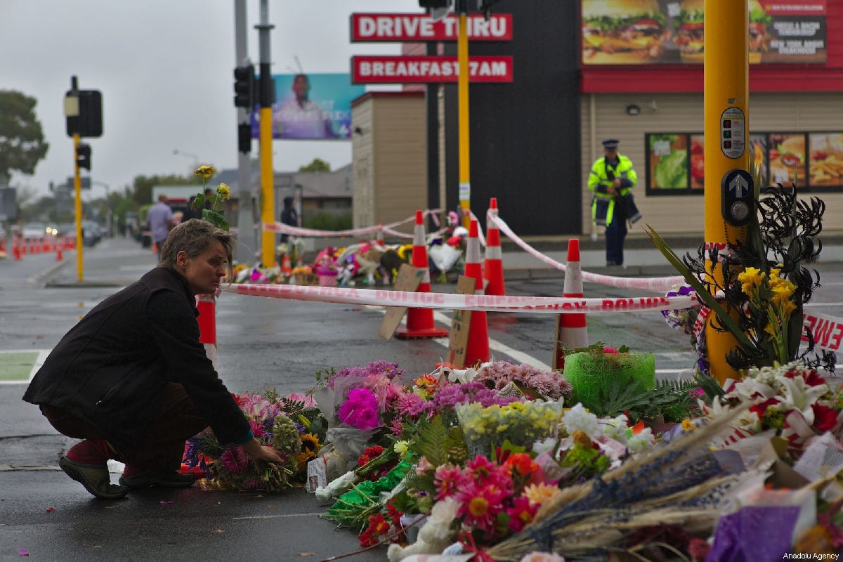 A woman lays flowers to pay tribute at Linwood Ave public vigil, close to the Linwood Mosque shooting area, for victims who lost their lives during twin terror attacks in New Zealand mosques in Christchurch, New Zealand on March 17, 2019. [Peter Adones - Anadolu Agency]