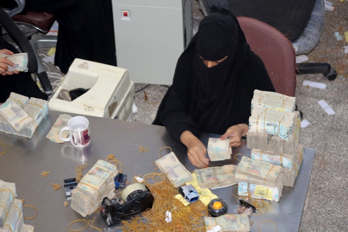 A bank teller counts money at the Central Bank of Aden in Aden on December 13, 2018 [Saleh Al-OBEIDI / AFP / Getty]