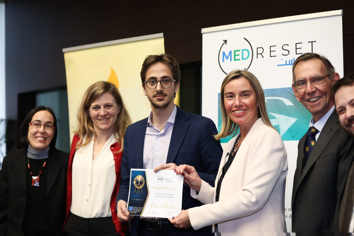 Omar Shanti [centre], winner of the European Union (EU)’s Young Writers Prize, receives a ceritificate from Federica Mogherini, the EU’s High Representative for Foreign Affairs and Security Policy and Vice-President of the European Council in Brussels, on March 6, 2019 [European Commission]